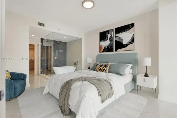 a bedroom with a large bed and a chandelier