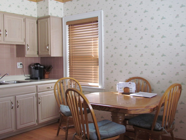 6952 West Foster Avenue Chicago, IL 60656 - Photo 4 of 14 a kitchen with a table chairs a sink and cabinets