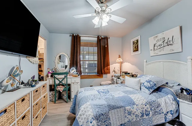 a bedroom with bed a flat tv screen and dresser