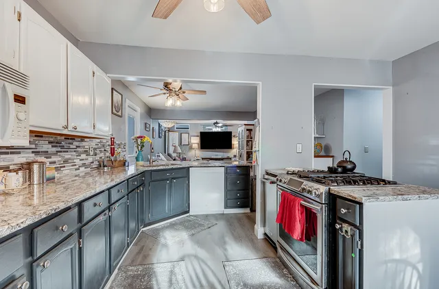a kitchen with stainless steel appliances granite countertop a stove sink and cabinets