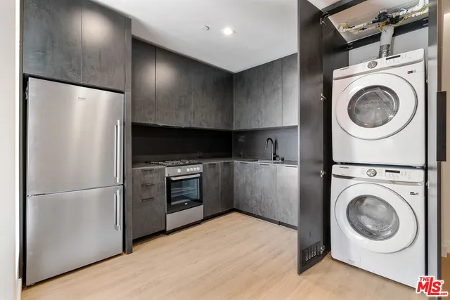 a kitchen with a refrigerator and a washer dryer