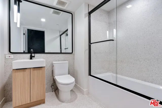 a bathroom with a toilet a sink and mirror