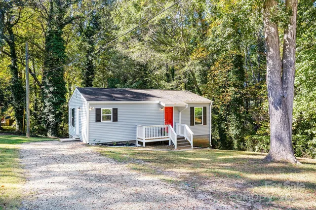a view of a house with backyard and trees
