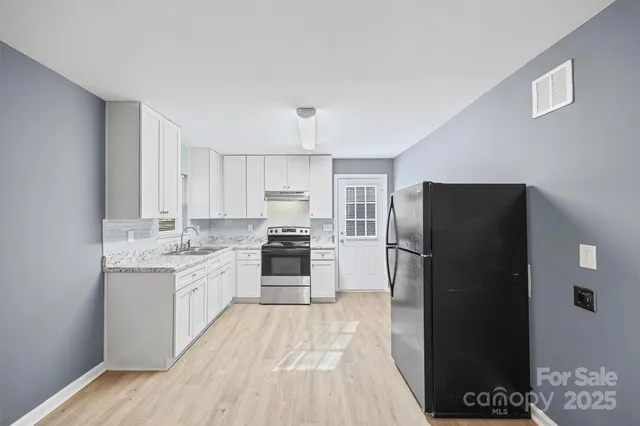 a kitchen with a refrigerator and a stove top oven