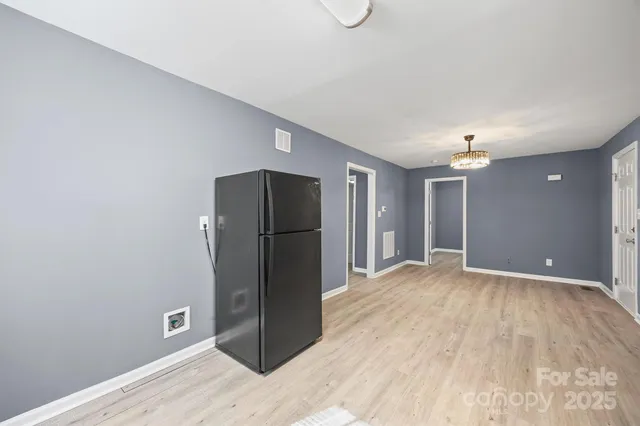 a view of an empty room with closet and a window