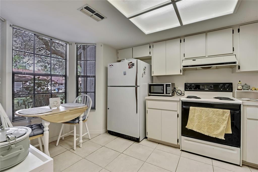 2111 Forester Way Spring Hill, FL 34606 - Photo 11 of 33 a kitchen with a refrigerator a stove a dining table and chairs