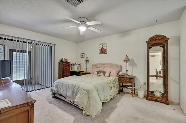 a bedroom with a bed a ceiling fan and a dresser