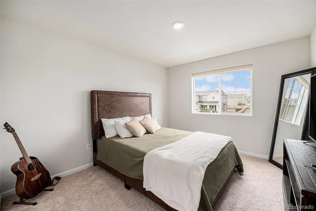 a bedroom with a bed next to a window