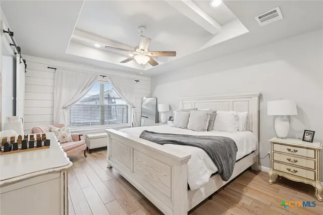 a spacious bedroom with a bed and a chandelier