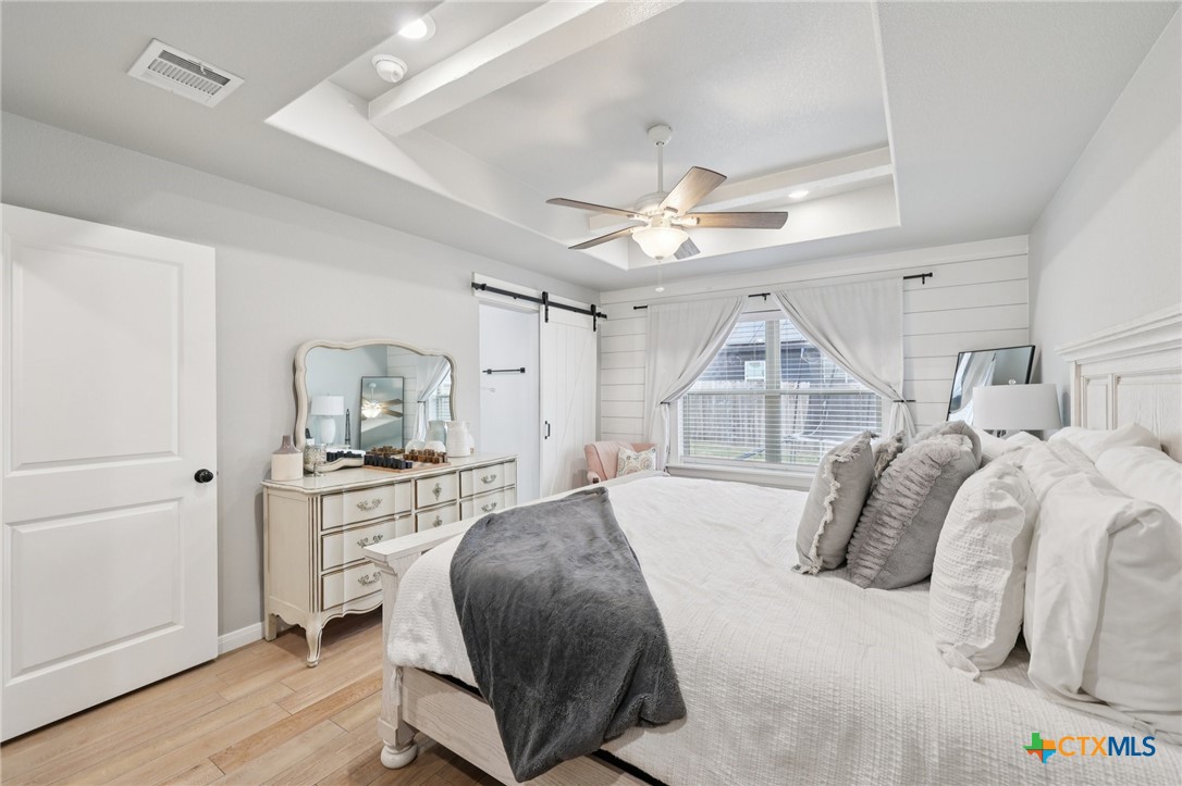 1522 Curlew Lane Temple, TX 76502 - Photo 20 of 35 a bedroom with a bed a window and a chandelier