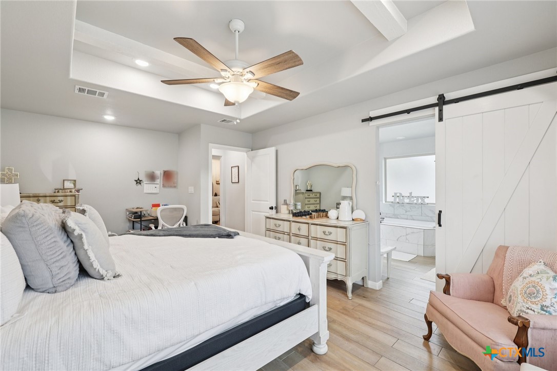 1522 Curlew Lane Temple, TX 76502 - Photo 21 of 35 a bedroom with a bed and a chandelier