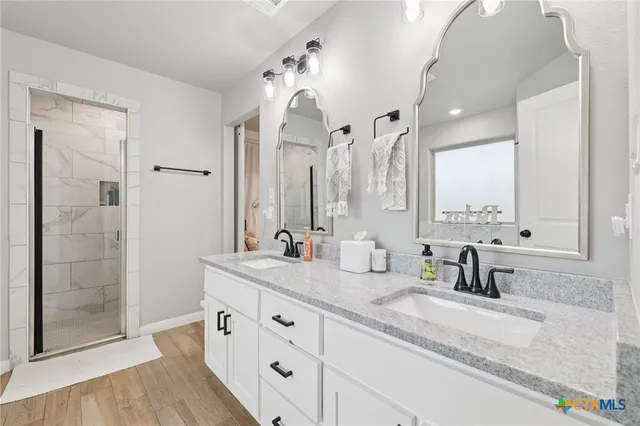 a bathroom with double vanity sink and mirror
