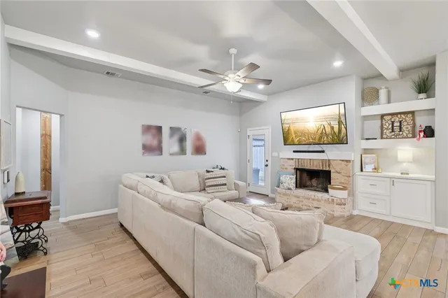 a living room with furniture a fireplace and a flat screen tv