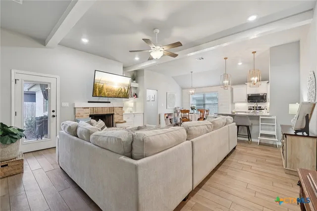 a living room with furniture a fireplace and a flat screen tv
