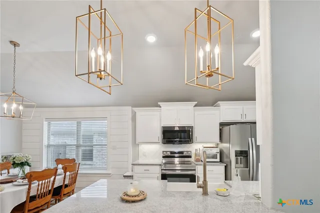 a kitchen with stainless steel appliances a stove a sink and cabinets