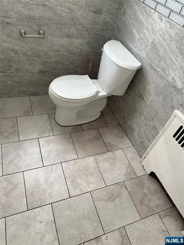 a white toilet sitting next to a white wall