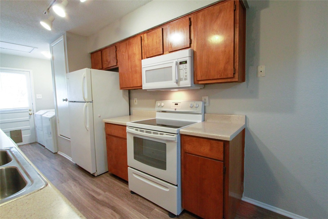 12609 Turtle Rock Road, Unit B Austin, TX 78729 - Photo 13 of 25 a kitchen with a white stove top oven and refrigerator