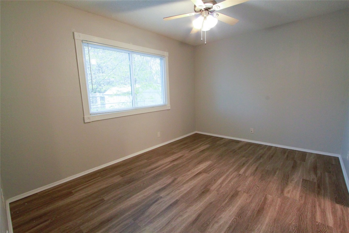 12609 Turtle Rock Road, Unit B Austin, TX 78729 - Photo 15 of 25 an empty room with wooden floor and windows