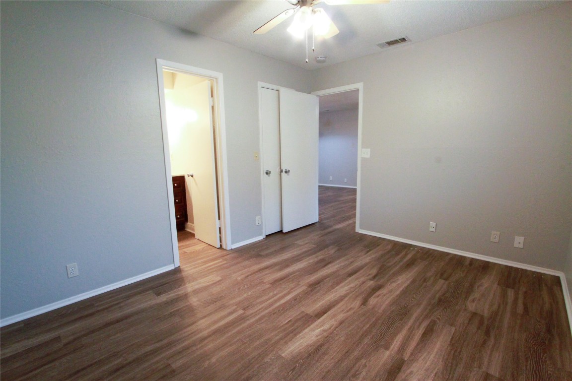12609 Turtle Rock Road, Unit B Austin, TX 78729 - Photo 16 of 25 an empty room with wooden floor and windows