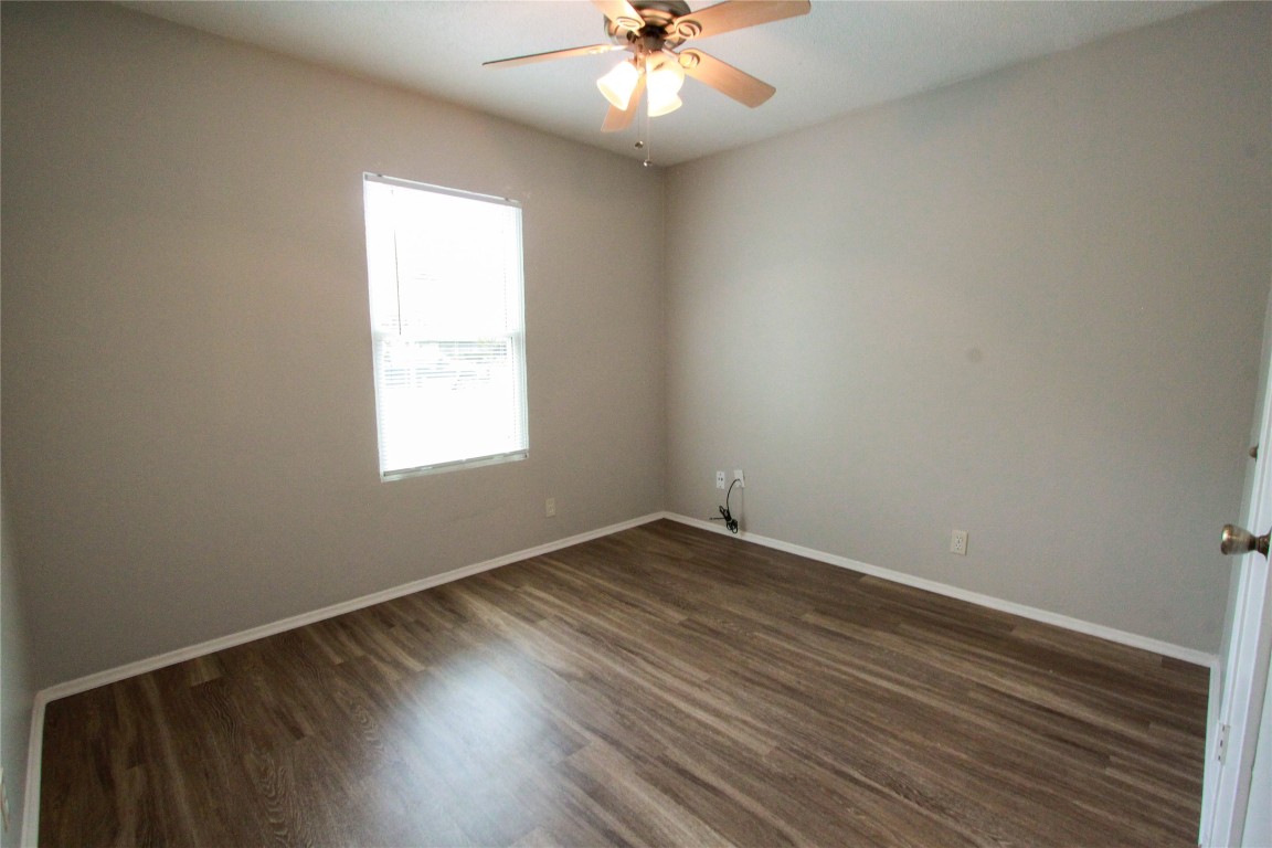 12609 Turtle Rock Road, Unit B Austin, TX 78729 - Photo 18 of 25 an empty room with wooden floor and windows