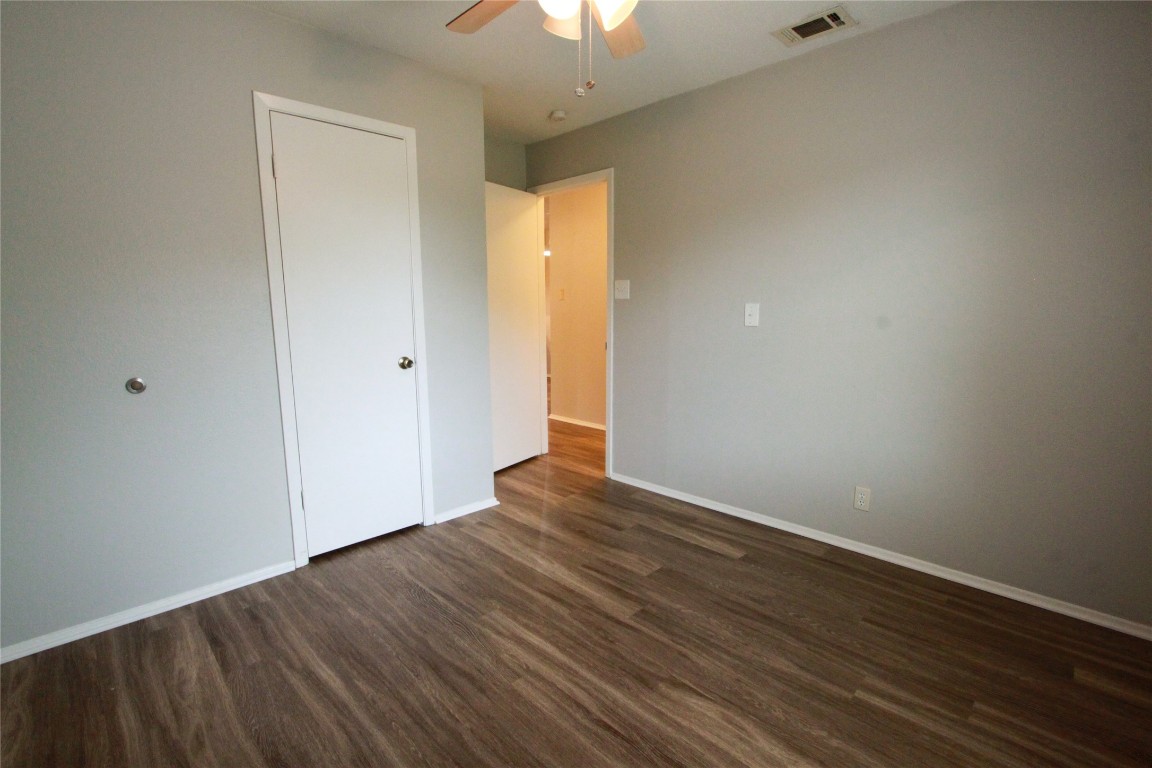12609 Turtle Rock Road, Unit B Austin, TX 78729 - Photo 19 of 25 a view of an empty room with wooden floor and a window
