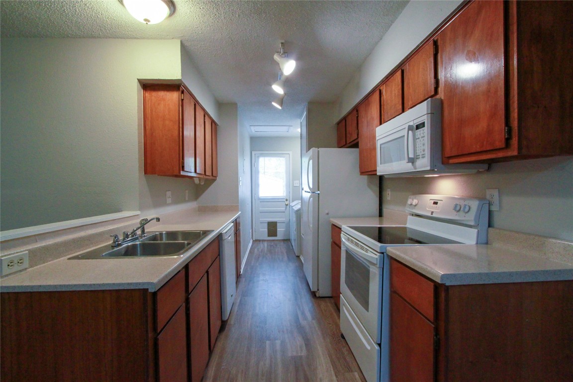 12609 Turtle Rock Road, Unit B Austin, TX 78729 - Photo 5 of 25 a kitchen with stainless steel appliances granite countertop a sink stove and refrigerator