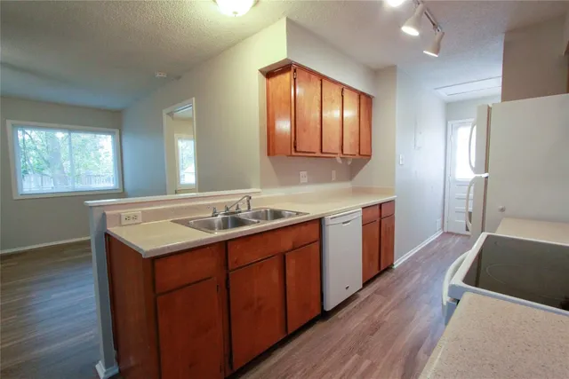 a kitchen with a stove sink and wooden floor