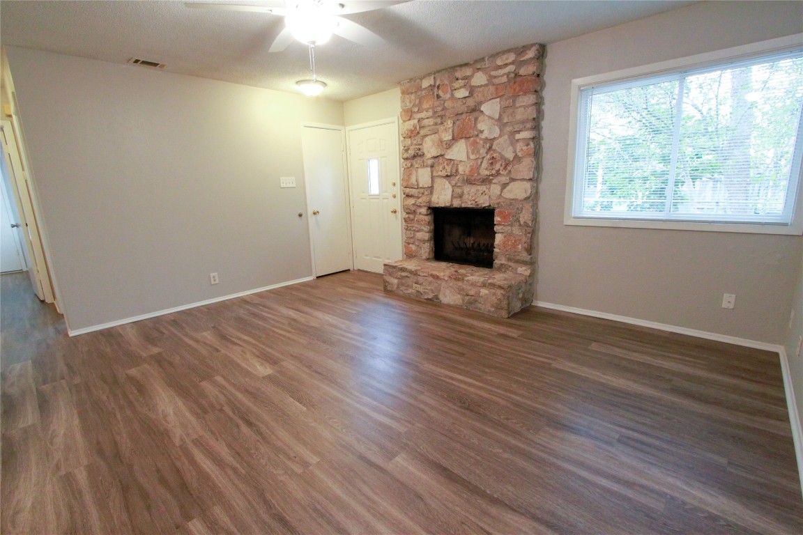 12609 Turtle Rock Road, Unit B Austin, TX 78729 - Photo 9 of 25 a view of empty room with wooden floor and fireplace