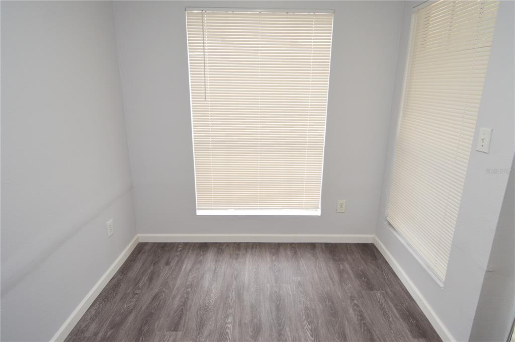 8641 Fancy Finch Drive, Unit 103 Tampa, FL 33614 - Photo 11 of 92 an empty room with wooden floor and windows