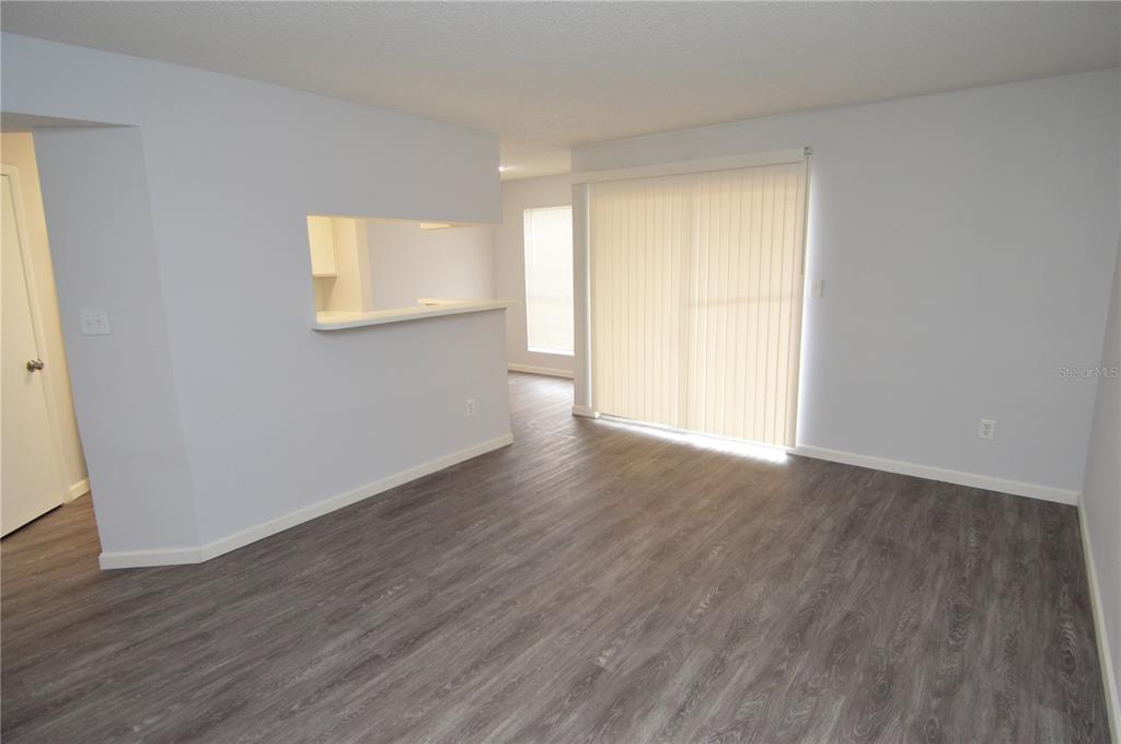 8641 Fancy Finch Drive, Unit 103 Tampa, FL 33614 - Photo 13 of 92 a view of an empty room with wooden floor and a window