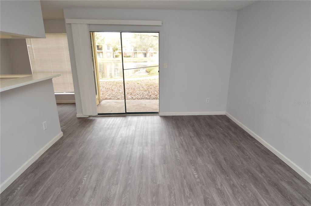 8641 Fancy Finch Drive, Unit 103 Tampa, FL 33614 - Photo 16 of 92 an empty room with wooden floor and windows