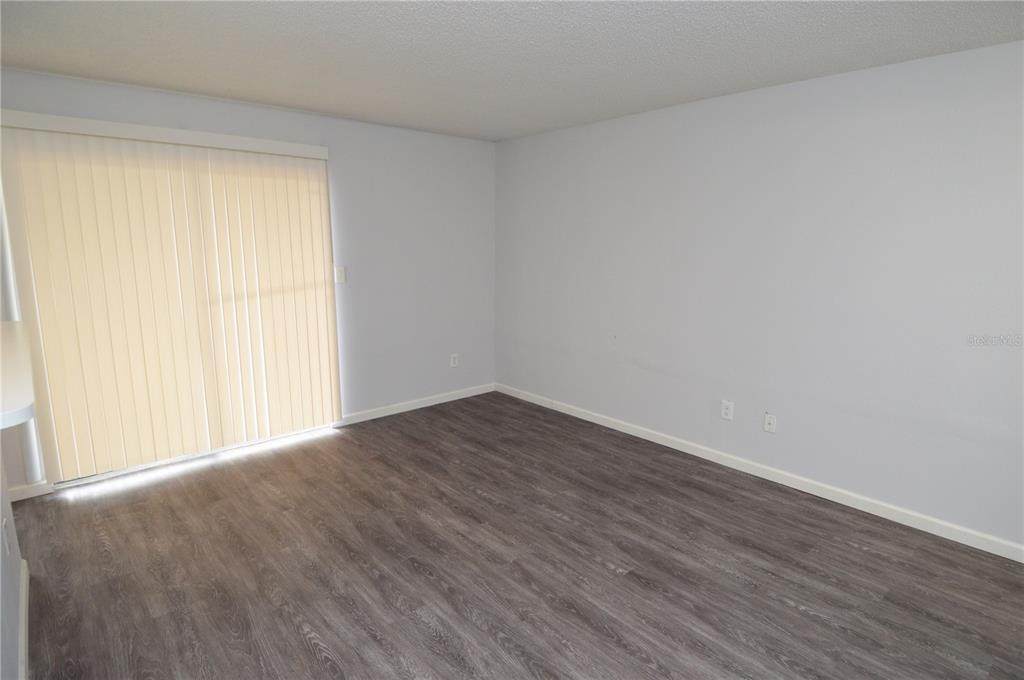 8641 Fancy Finch Drive, Unit 103 Tampa, FL 33614 - Photo 17 of 92 a view of an empty room with wooden floor and a window