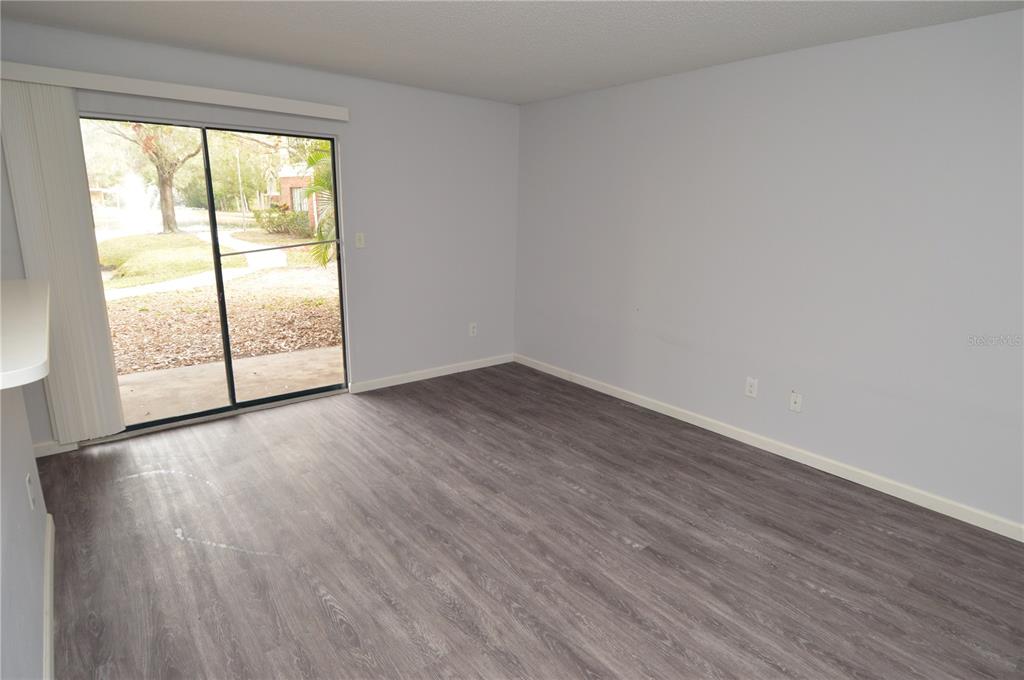 8641 Fancy Finch Drive, Unit 103 Tampa, FL 33614 - Photo 18 of 92 a view of an empty room with wooden floor and a window