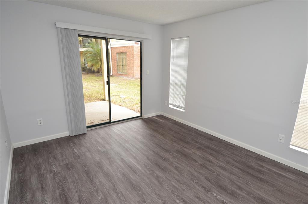 8641 Fancy Finch Drive, Unit 103 Tampa, FL 33614 - Photo 31 of 92 an empty room with wooden floor and windows