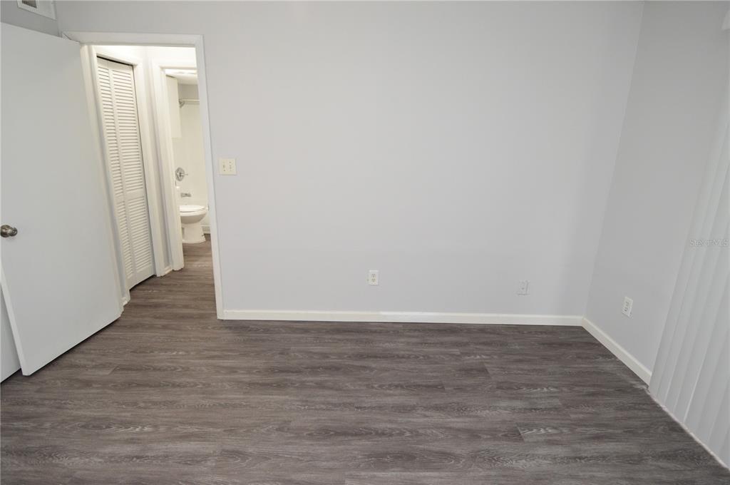 8641 Fancy Finch Drive, Unit 103 Tampa, FL 33614 - Photo 37 of 92 a view of an empty room with wooden floor and a window