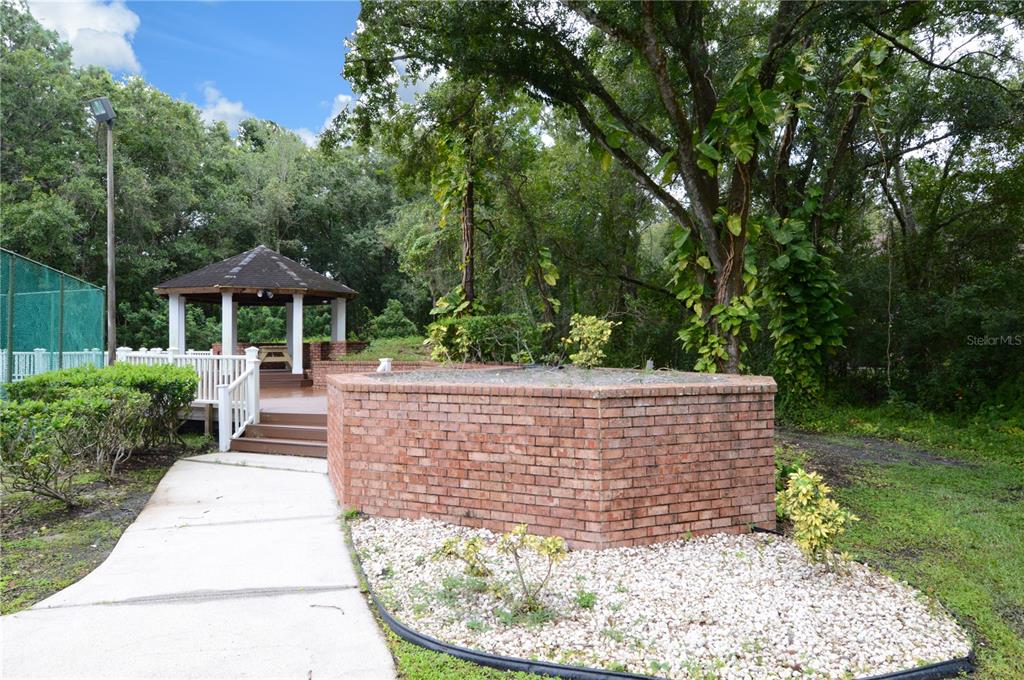 8641 Fancy Finch Drive, Unit 103 Tampa, FL 33614 - Photo 49 of 92 a view of a patio with table and chairs potted plants and large tree