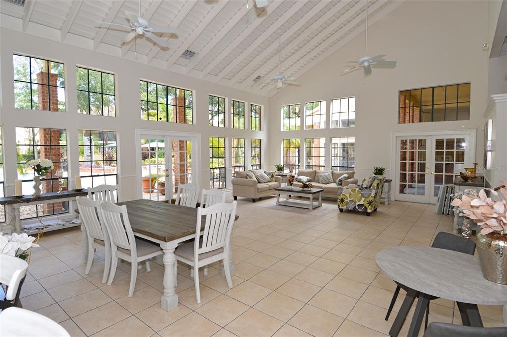 8641 Fancy Finch Drive, Unit 103 Tampa, FL 33614 - Photo 63 of 92 a view of a dining room with furniture large windows and wooden chandelier