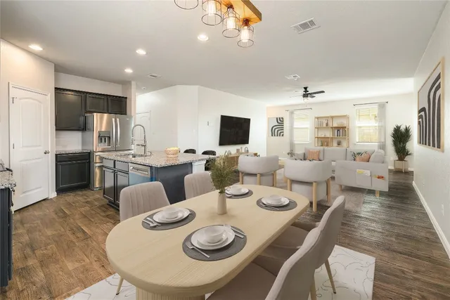 a living room with lots of white furniture and kitchen view