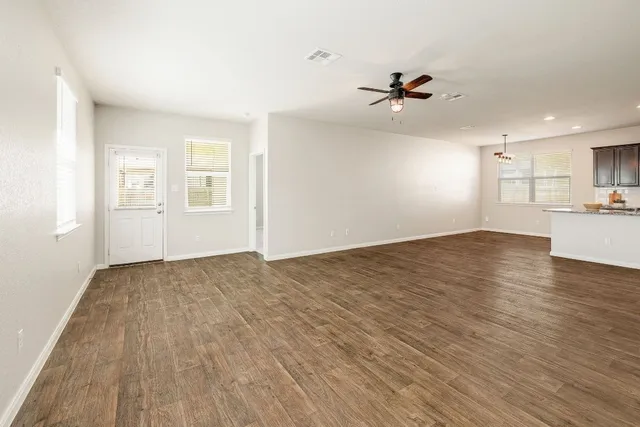 a view of a kitchen with wooden floor and a ceiling fan