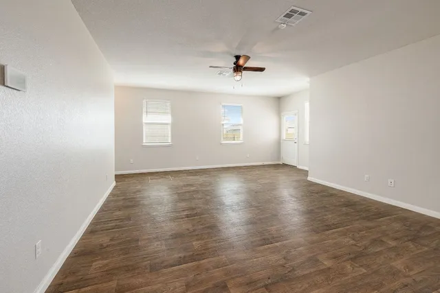 wooden floor in an empty room with a window