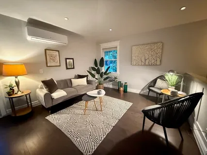 a living room with furniture a rug and a lamp