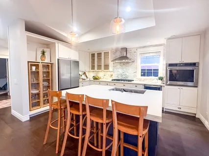 a kitchen with kitchen island a dining table and chairs