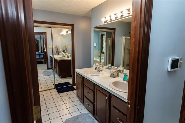 a bathroom with a tub a sink and a large mirror