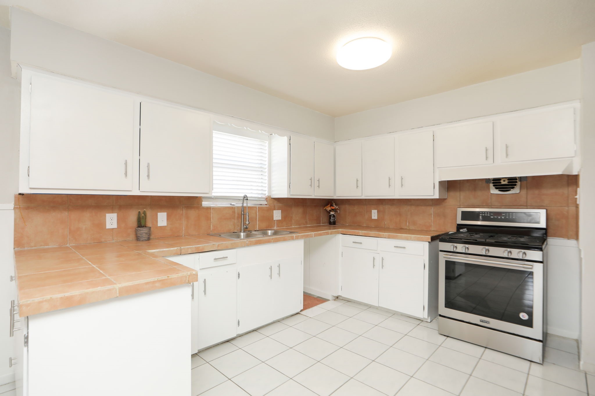 8235 Dover Street Houston, TX 77061 - Photo 15 of 36 a kitchen with a stove sink and cabinets