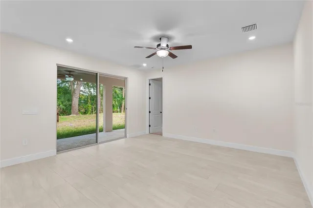 an empty room with fan and windows