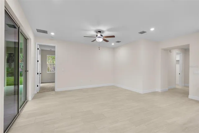 an empty room with fan and entrance