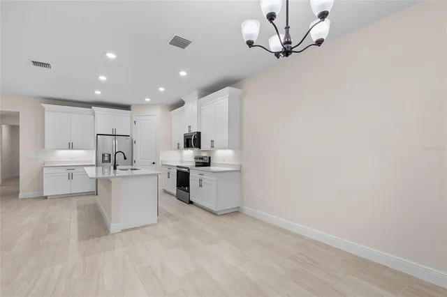 a kitchen with white cabinets and counter