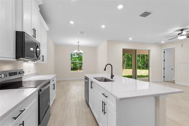 a kitchen with stainless steel appliances a sink stove and cabinets