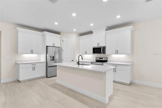 a kitchen with appliances a sink and cabinets