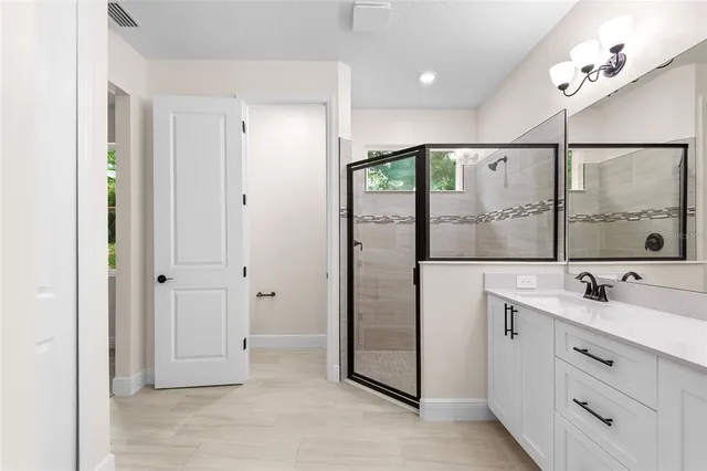 a bathroom with a double vanity sink a mirror and a shower